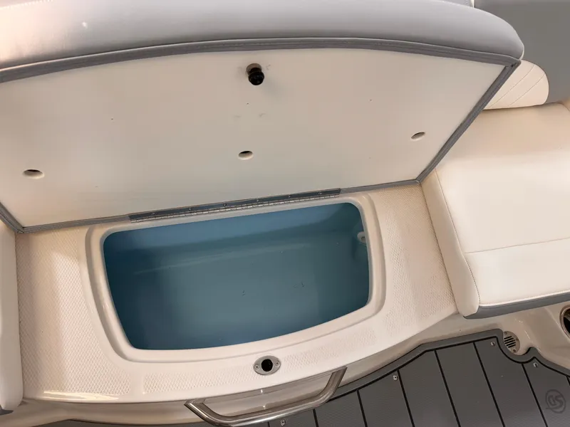 Slide: The Image of 2025 Chaparral 21 SSi OB boat storage compartment with open lid and blue interior. - 31
