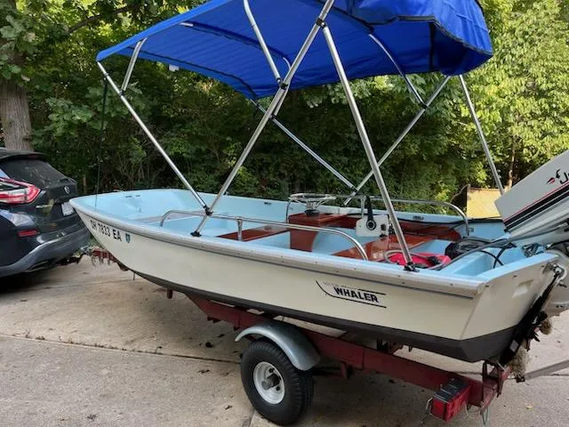 Slide: The Image of 1964 Boston Whaler 13 Sport boat with blue canopy on trailer, parked outdoors. - 2