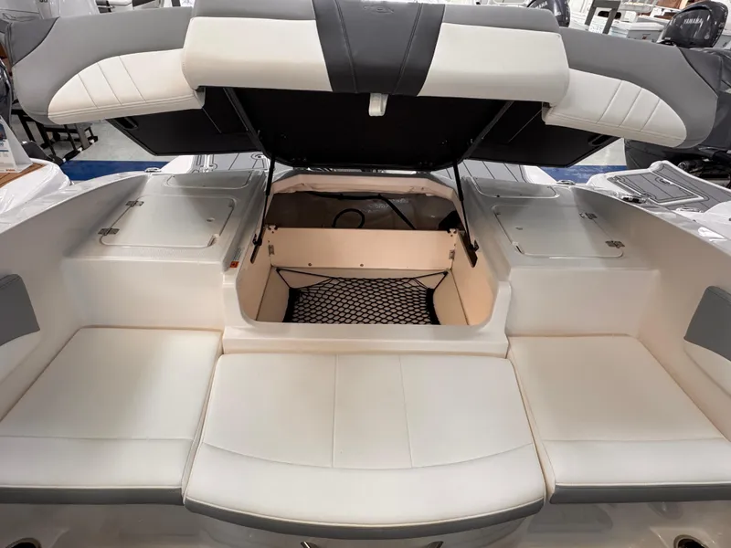 Slide: The Image of 2025 Chaparral 21 SSi OB boat interior with open storage compartment and cushioned seating. - 29