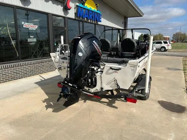 Slide: The Image of 2021 Tracker Pro Guide V-16 WT boat with Mercury engine, parked outside a marine store. - 3