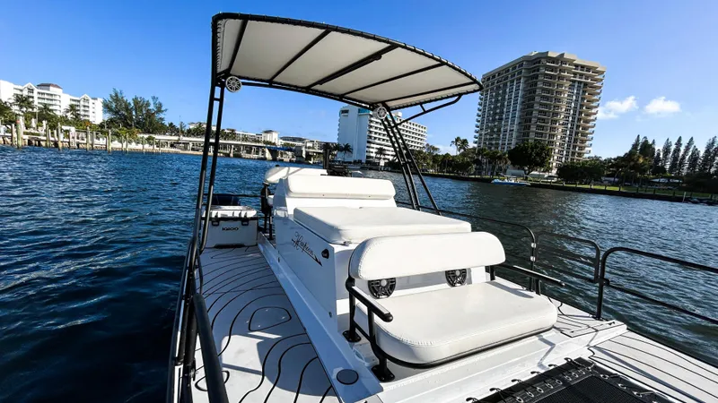 Slide: The Image of 2025 Pontoon Harpoon boat on water, cityscape background, sunny day. - 12