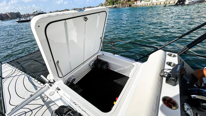 Slide: The Image of 2025 Pontoon Harpoon boat with open storage compartment on a sunny day by the water. - 19