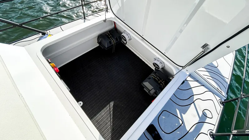 Slide: The Image of Open storage compartment on 2025 Pontoon Harpoon boat, featuring secure battery placement. - 20