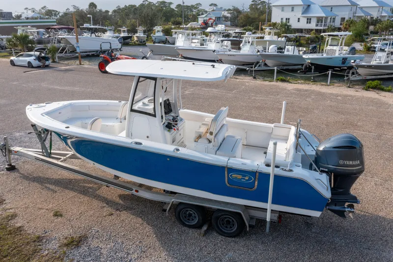 Slide: The Image of 2018 Sea Hunt 255 SE boat on trailer, blue hull, Yamaha engine, parked in marina. - 2