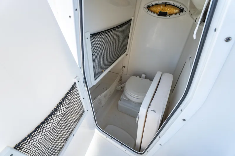 Slide: The Image of 2018 Sea Hunt 255 SE boat interior with compact marine toilet and storage nets. - 23