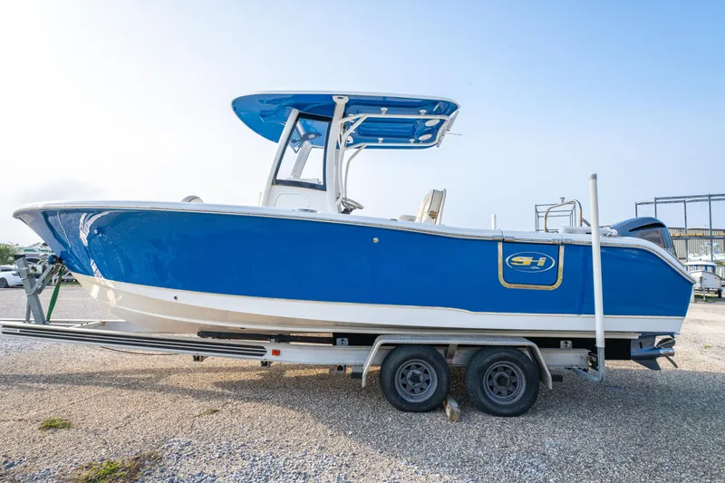 Slide: The Image of 2018 Sea Hunt 255 SE boat on trailer, blue and white design. - 8