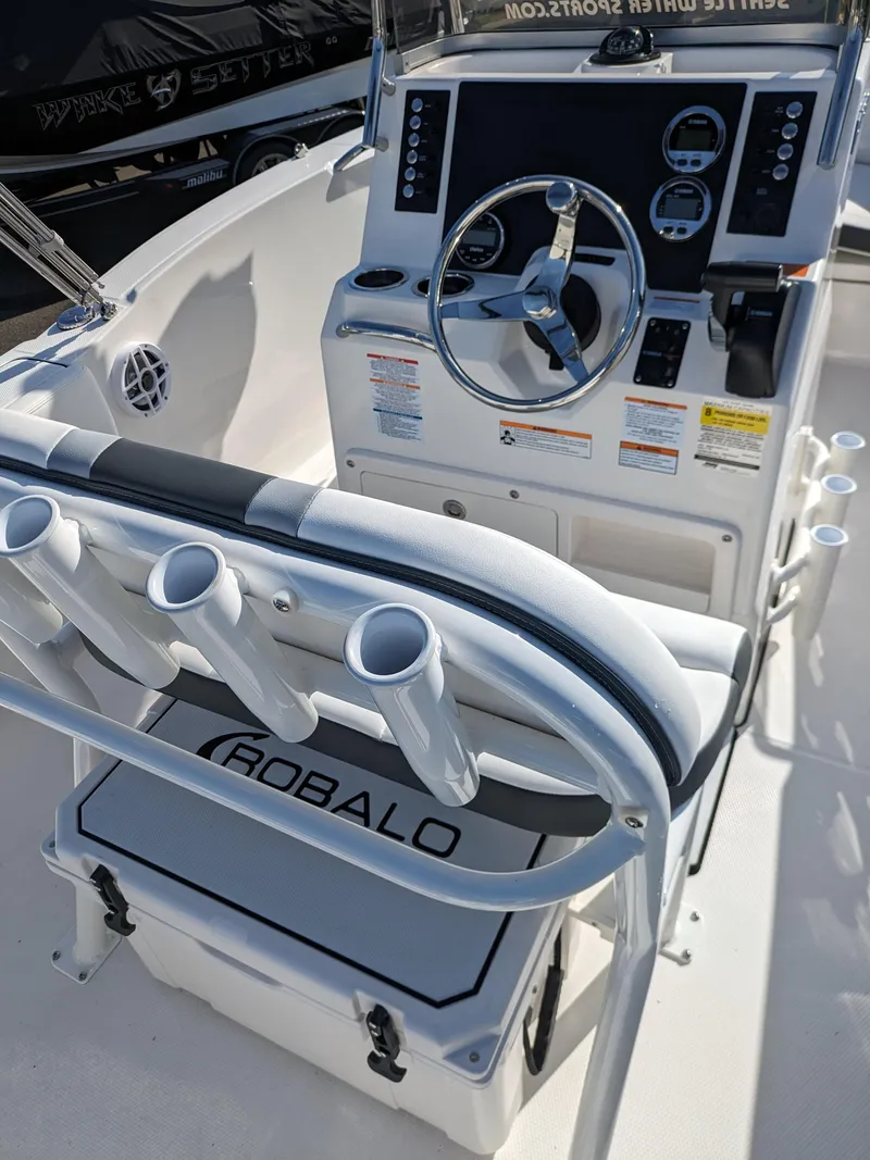 Slide: The Image of 2025 Robalo R180 Center Console boat interior with steering wheel and rod holders. - 15