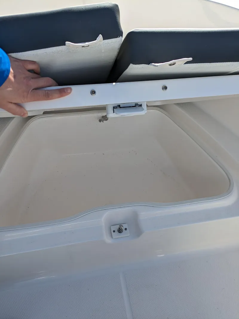 Slide: The Image of 2025 Robalo R180 Center Console storage compartment with open lid. - 21