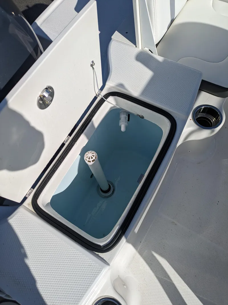 Slide: The Image of 2025 Robalo R180 Center Console livewell with open lid, showcasing interior design. - 22