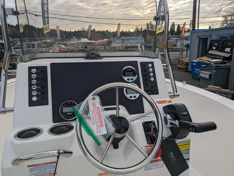 Slide: The Image of 2025 Robalo R180 Center Console boat dashboard with steering wheel and controls. - 7