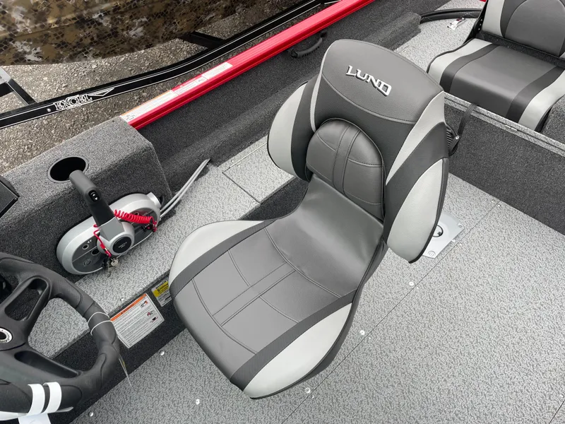 Slide: The Image of 2025 Lund 1650 Rebel XL Sport boat interior with gray seating and steering controls. - 18
