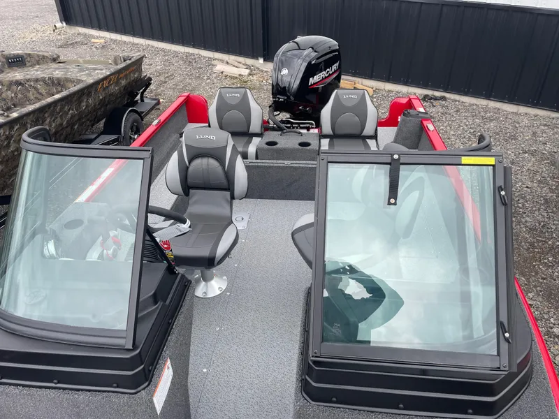 Slide: The Image of 2025 Lund 1650 Rebel XL Sport boat with Mercury engine, featuring dual windshields and seating. - 26