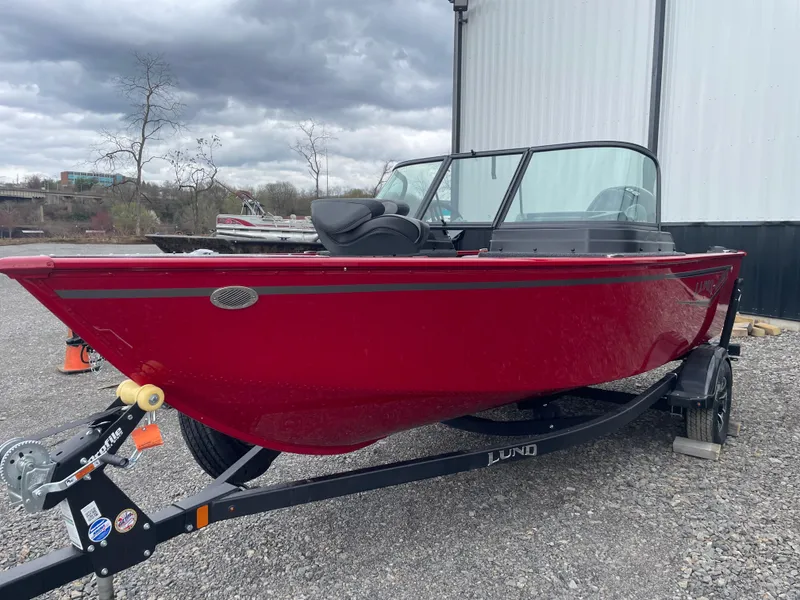 Slide: The Image of 2025 Lund 1650 Rebel XL Sport boat in red on a trailer, parked outdoors. - 8