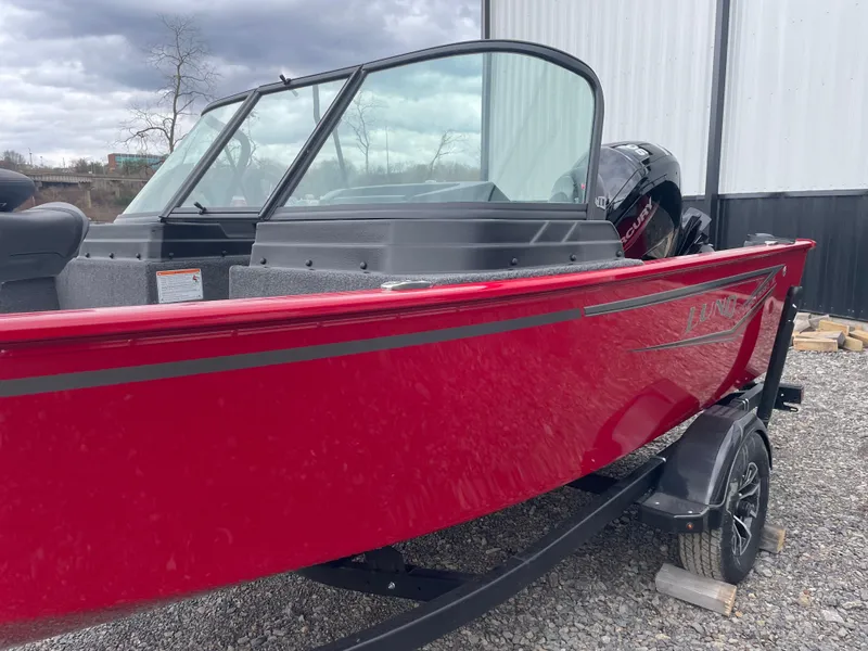 Slide: The Image of 2025 Lund 1650 Rebel XL Sport boat, red exterior, parked on gravel near a building. - 9