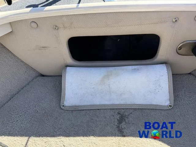 Slide: The Image of 2002 Crestliner Super Hawk 1700 interior storage compartment, featuring a beige carpeted finish. - 15