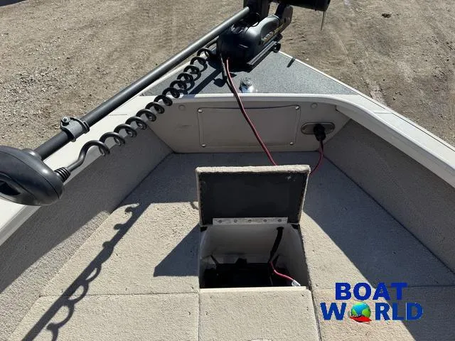 Slide: The Image of 2002 Crestliner Super Hawk 1700 boat interior with open storage compartment and trolling motor. - 18