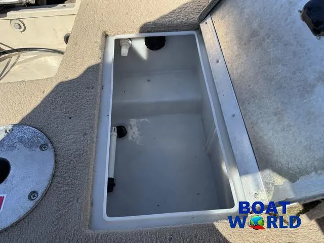Slide: The Image of Open storage compartment in 2002 Crestliner Super Hawk 1700 boat, featuring beige carpeted interior. - 48