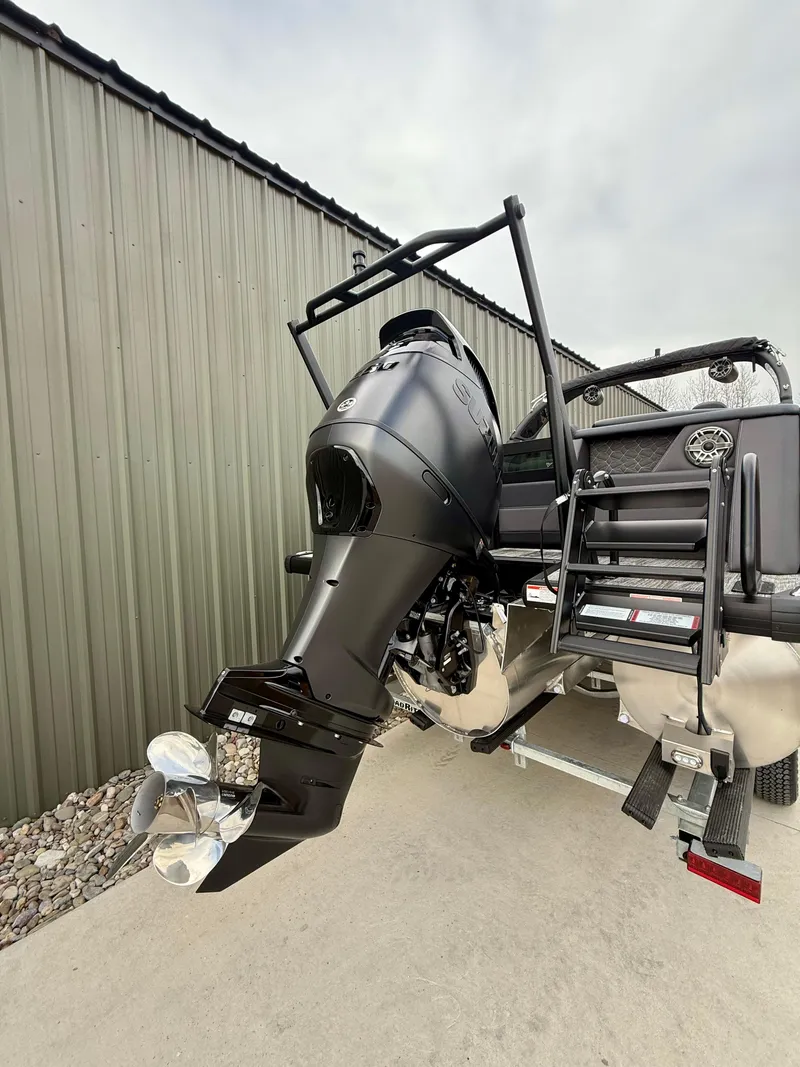 Slide: The Image of 2025 Viaggio Diamante UWA boat with powerful outboard motor, docked near a metal building. - 13