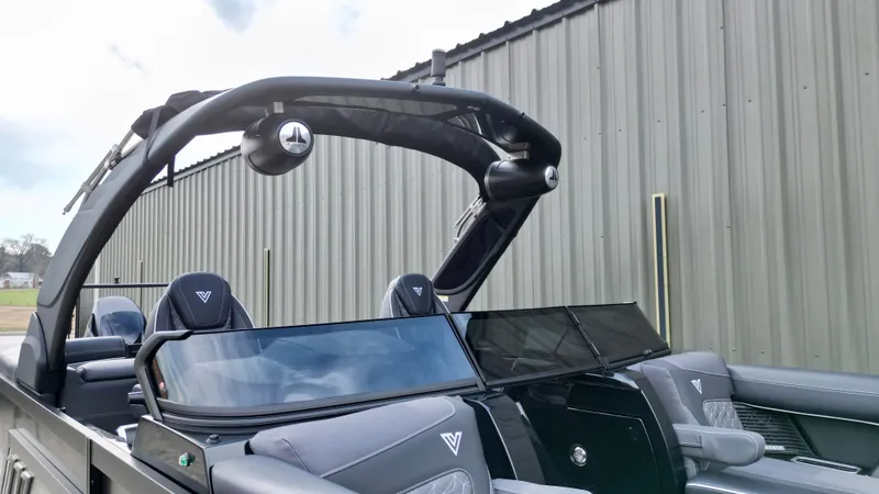 Slide: The Image of 2025 Viaggio Diamante UWA boat with sleek design and modern seating near a metal building. - 15