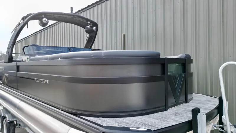 Slide: The Image of 2025 Viaggio Diamante UWA pontoon boat with sleek design, docked near a metal building. - 16