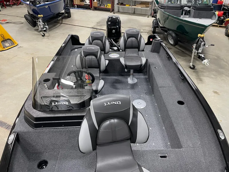 Slide: The Image of 2025 Lund 1650 Rebel XL Blackout boat with Mercury engine in a garage setting. - 3