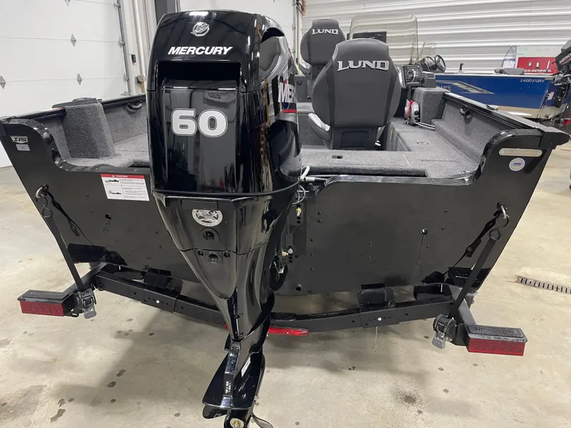 Slide: The Image of 2025 Lund 1650 Rebel XL Blackout boat with Mercury 60 engine in a garage setting. - 4