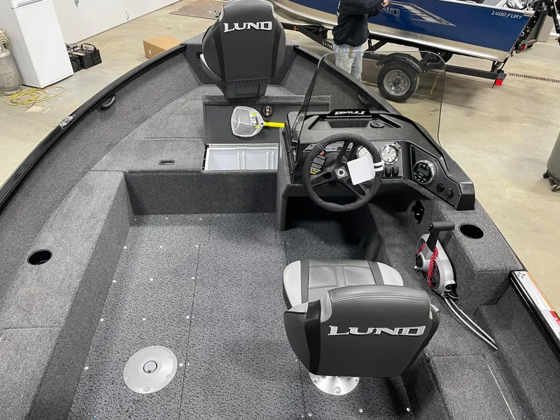 Slide: The Image of 2025 Lund 1650 Rebel XL Blackout boat interior with steering console and seating. - 7