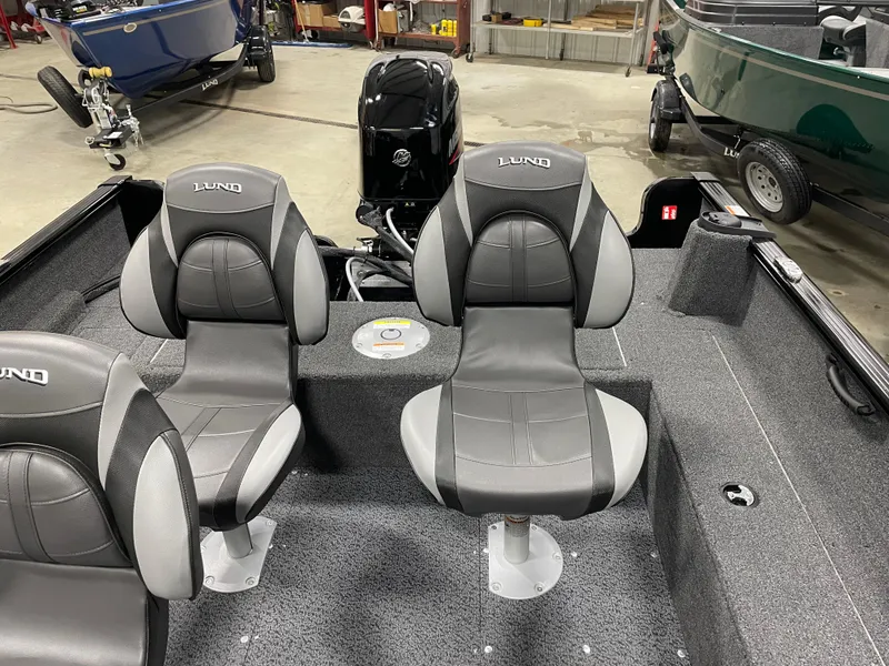 Slide: The Image of 2025 Lund 1650 Rebel XL Blackout boat interior with two gray seats and motor. - 8