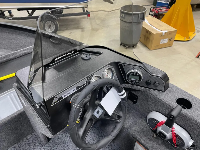 Slide: The Image of 2025 Lund 1650 Rebel XL Blackout boat dashboard with steering wheel and controls. - 9