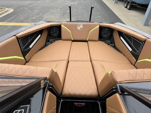 Slide: The Image of 2022 Tigé 24 RZK boat interior with tan quilted seating and green accents. - 21