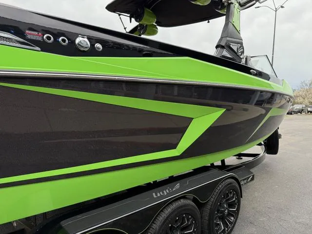 Slide: The Image of 2022 Tigé 24 RZK boat with green and black design on a trailer. - 24