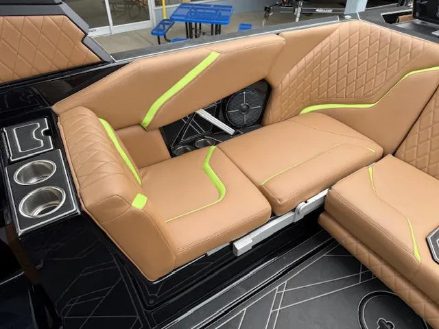 Slide: The Image of 2022 Tigé 24 RZK boat interior with tan and green upholstery, cup holders, and speaker. - 9