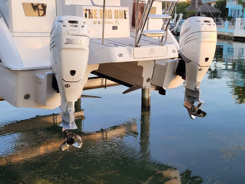 Slide: The Image of Aquila 36 Sport 2019 boat with twin outboard engines docked in calm water. - 14