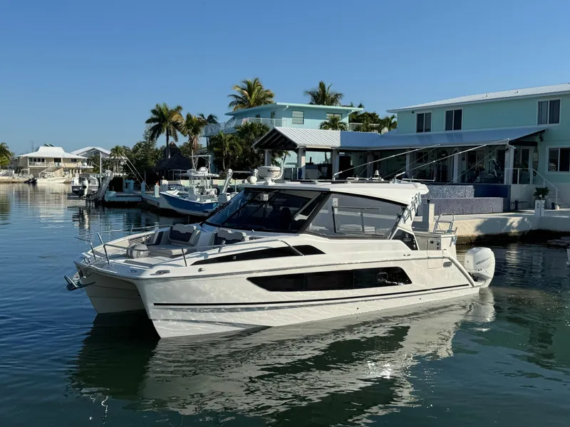 Slide: The Image of Aquila 36 Sport 2019 yacht docked in a sunny marina with palm trees. - 2