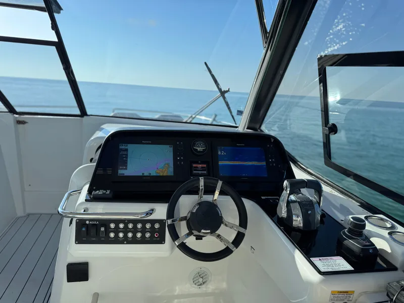 Slide: The Image of Cockpit of 2019 Aquila 36 Sport boat with navigation screens and steering wheel. - 27