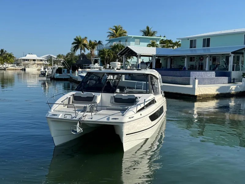 Slide: The Image of 2019 Aquila 36 Sport boat docked in a serene waterfront setting. - 4