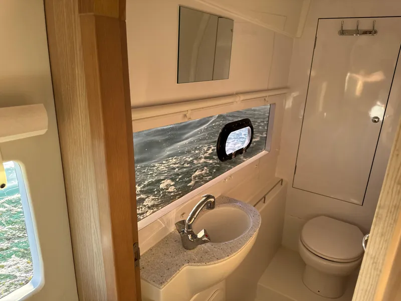 Slide: The Image of 2019 Aquila 36 Sport yacht bathroom with sink, toilet, and ocean view window. - 48