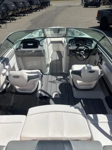 Slide: The Image of 2021 Chaparral 21 SSi boat interior with white seating and modern dashboard. - 11