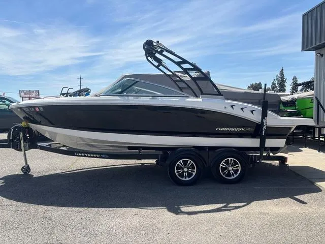 Slide: The Image of 2021 Chaparral 21 SSi boat on trailer, sleek design, parked outdoors. - 13
