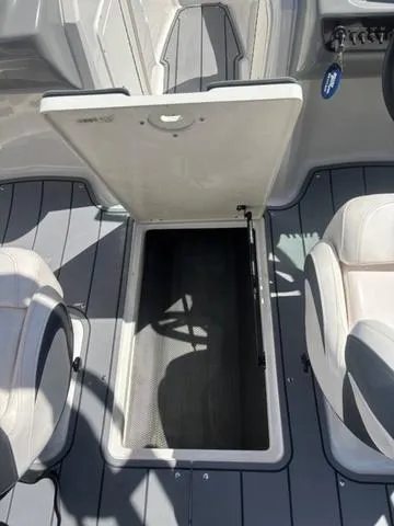 Slide: The Image of 2021 Chaparral 21 SSi boat interior with open storage compartment between seats. - 7