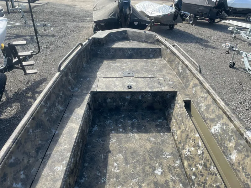 Slide: The Image of 2025 Excel 1751 River Warrior boat with camouflage interior, parked on gravel. - 13