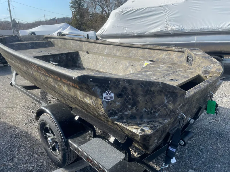 Slide: The Image of 2025 Excel 1751 River Warrior boat on trailer, camo design, outdoor setting. - 4
