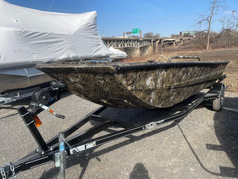 Slide: The Image of 2025 Excel 1751 River Warrior boat on trailer, camo design, parked outdoors. - 8