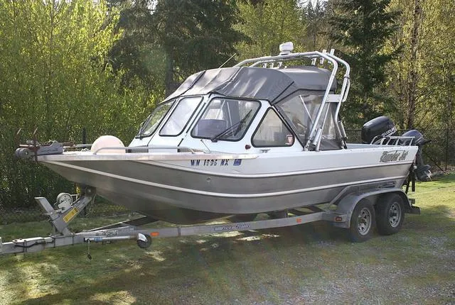 Slide: The Image of 2008 Thunder Jet 20 Luxor boat on trailer, parked outdoors with trees in background. - 1