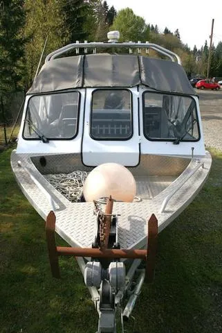 Slide: The Image of 2008 Thunder Jet 20 Luxor boat with canopy, parked on grass, surrounded by trees. - 13