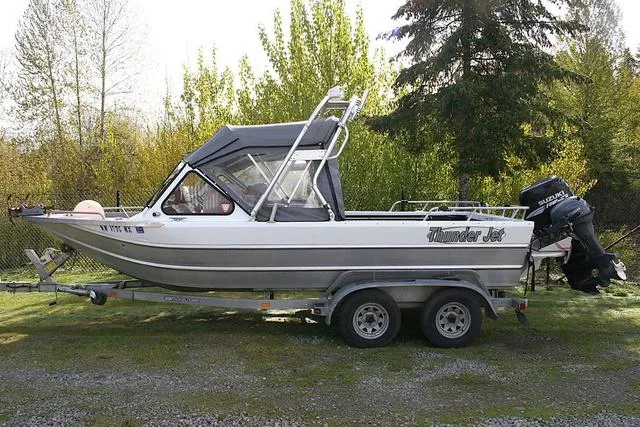 Slide: The Image of 2008 Thunder Jet 20 Luxor boat on trailer, parked outdoors with trees in background. - 2