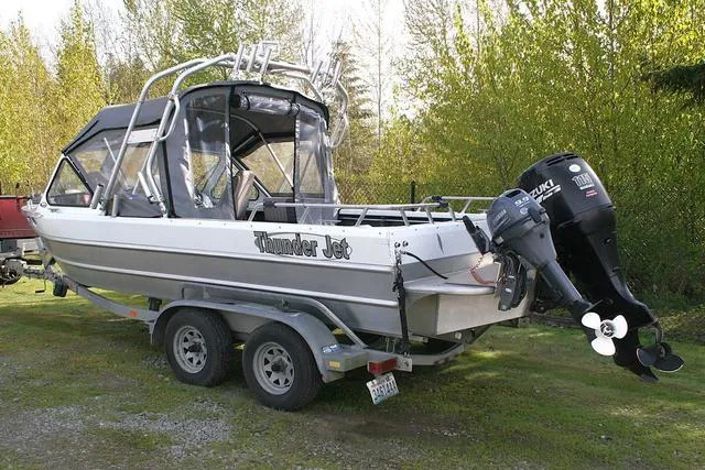 Slide: The Image of 2008 Thunder Jet 20 Luxor boat on trailer, parked outdoors with trees in background. - 3