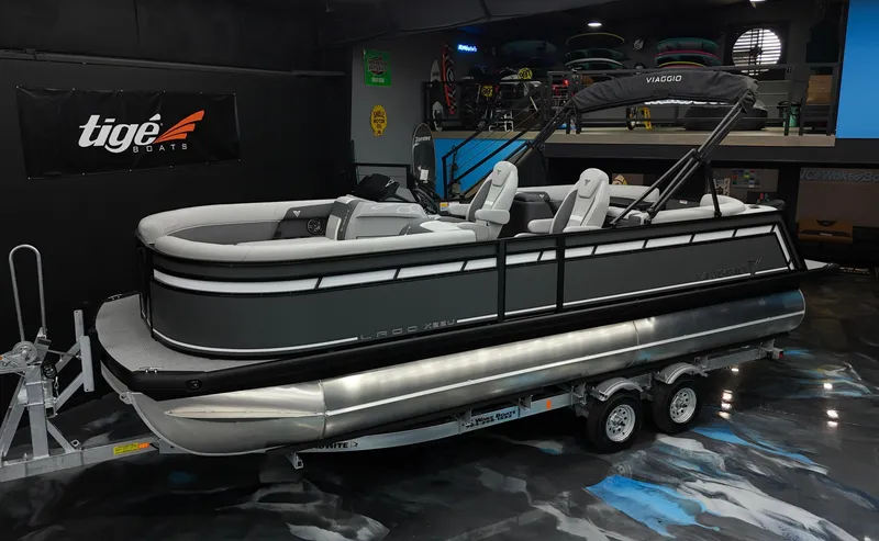 Slide: The Image of 2025 Viaggio Lago X-U pontoon boat on trailer in showroom. - 0