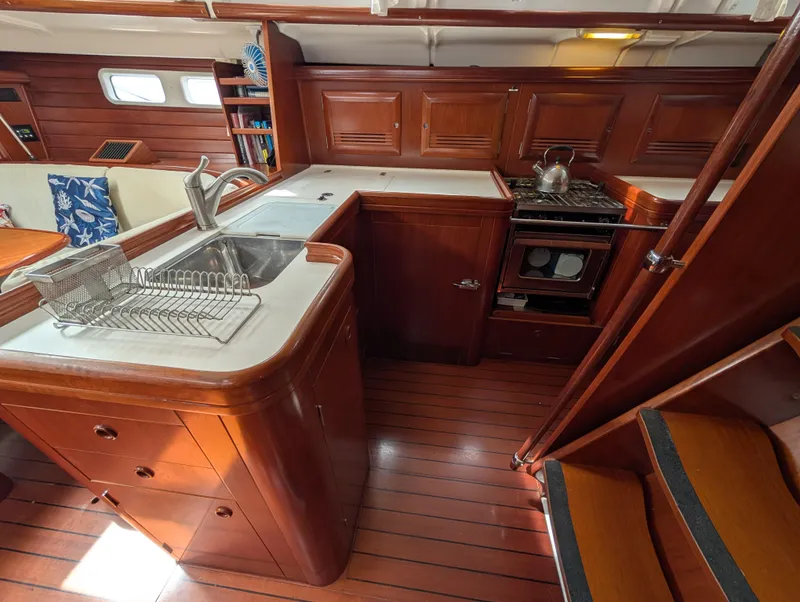 Slide: The Image of Interior of 2003 Beneteau Oceanis 473 yacht kitchen with wooden cabinetry and modern appliances. - 13