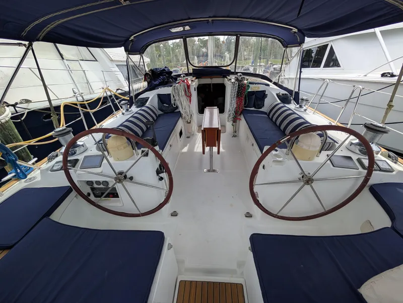 Slide: The Image of 2003 Beneteau Oceanis 473 sailboat cockpit with dual steering wheels and blue seating. - 29